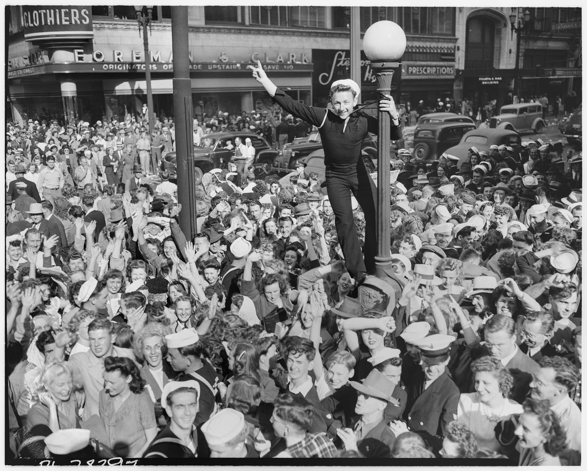 Image of Sailor climbing lamppost on V-J Day, Seattle, August 14, 1945