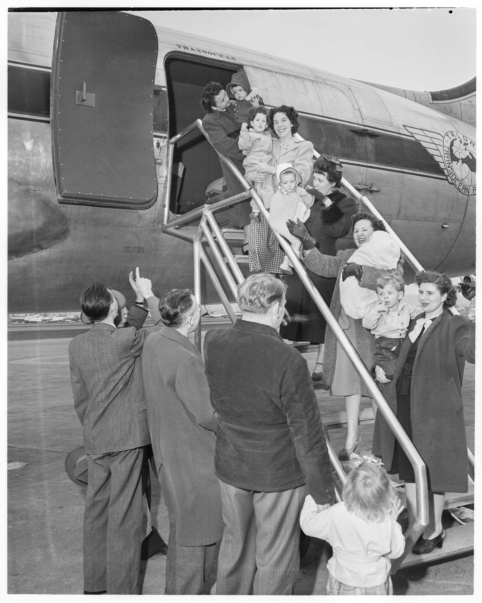 Image of War brides and children disembarking from plane, probably in Seattle, 1950