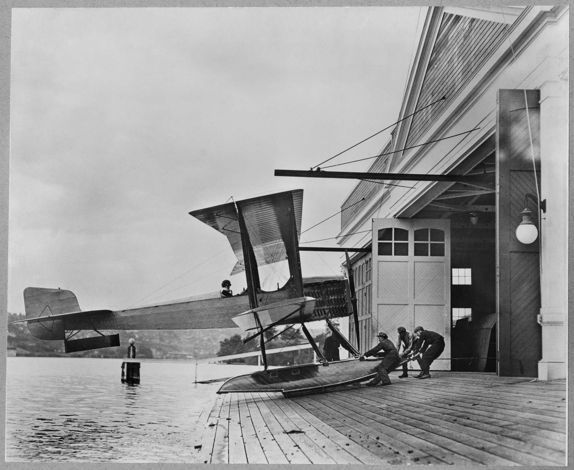 Image of Men pulling B & W into Boeing Seaplane Hangar on Lake Union, Seattle, 1916