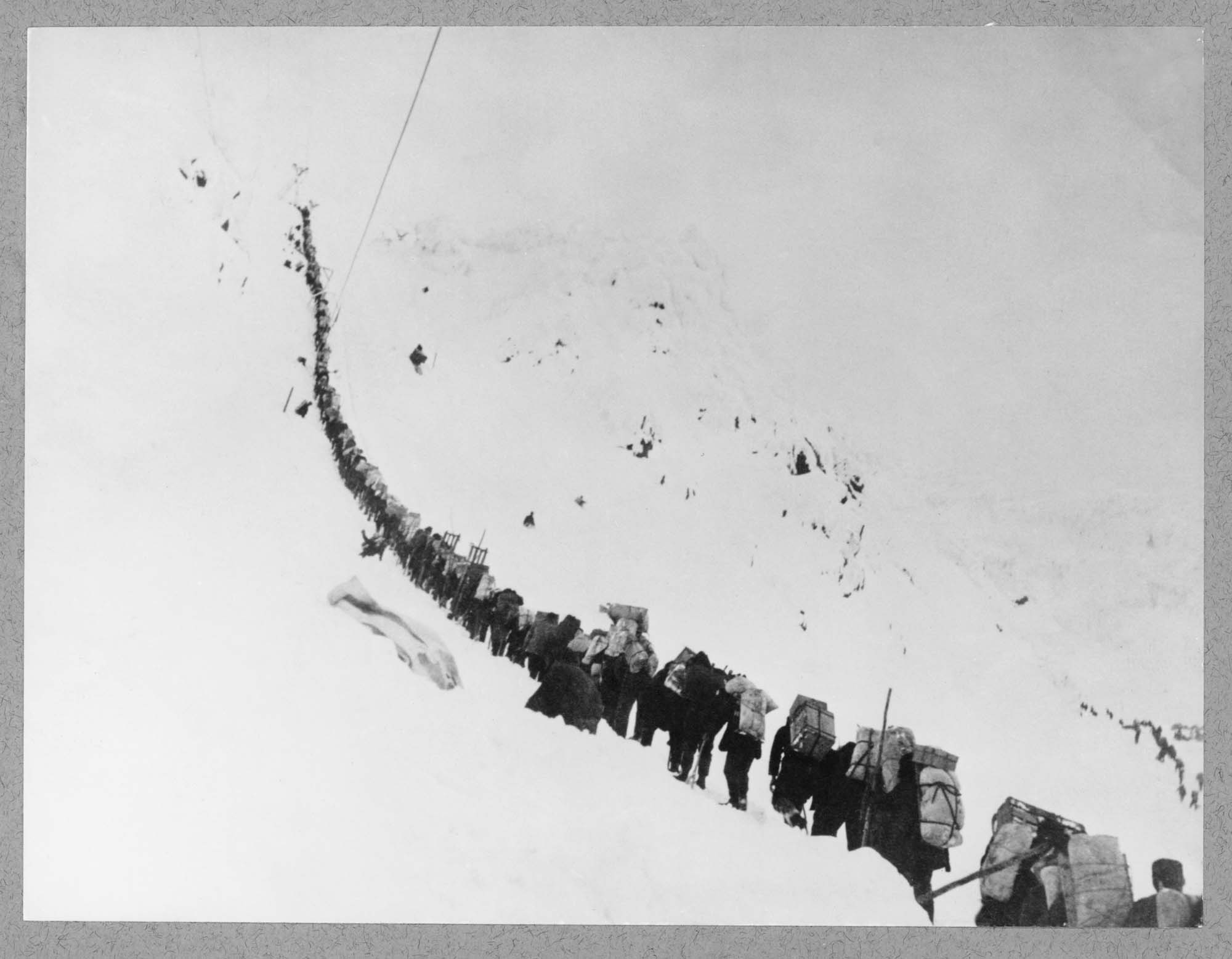 Image of Packers ascending summit of Chilkoot Pass, circa 1898