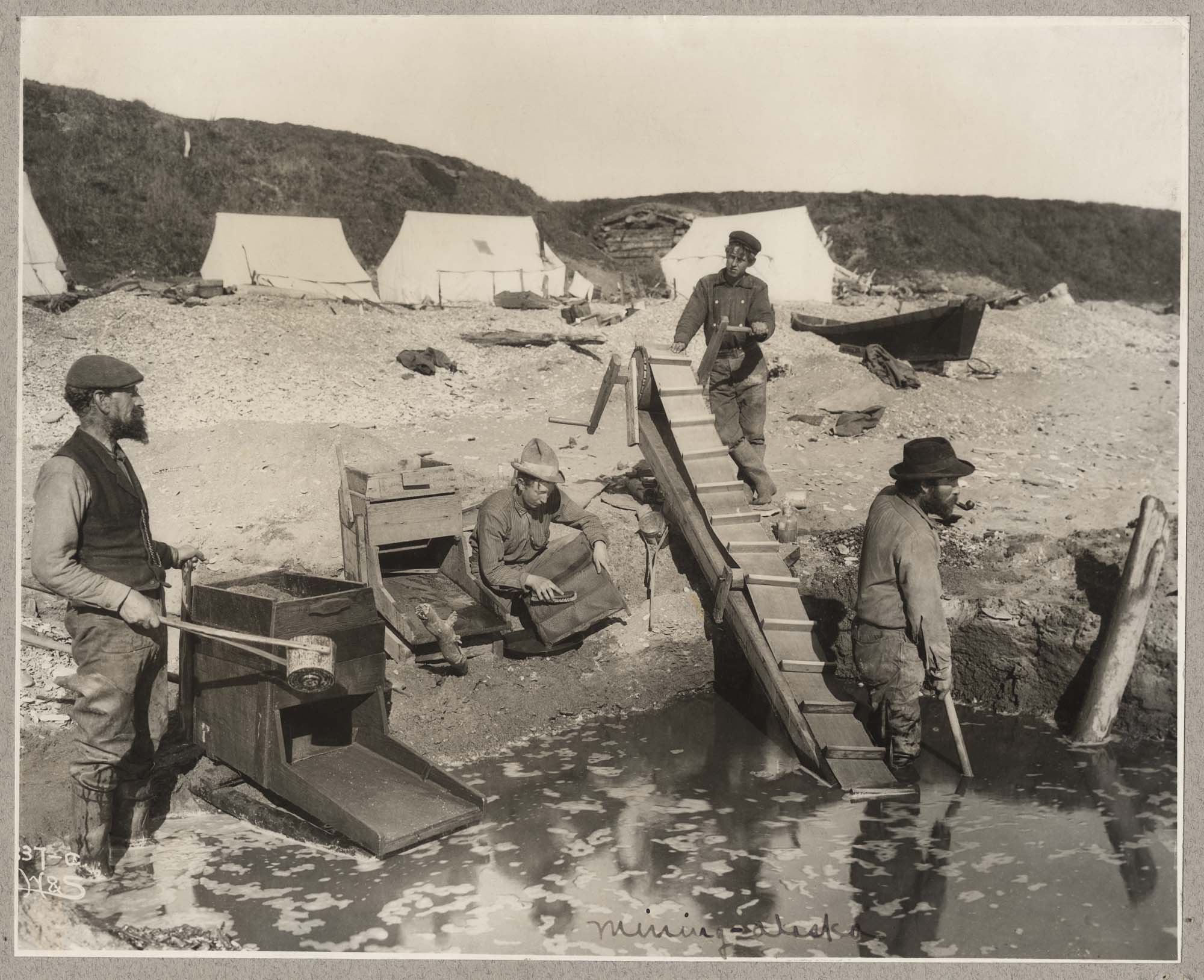 Image of Group of miners using conveyor and rockers, circa 1899