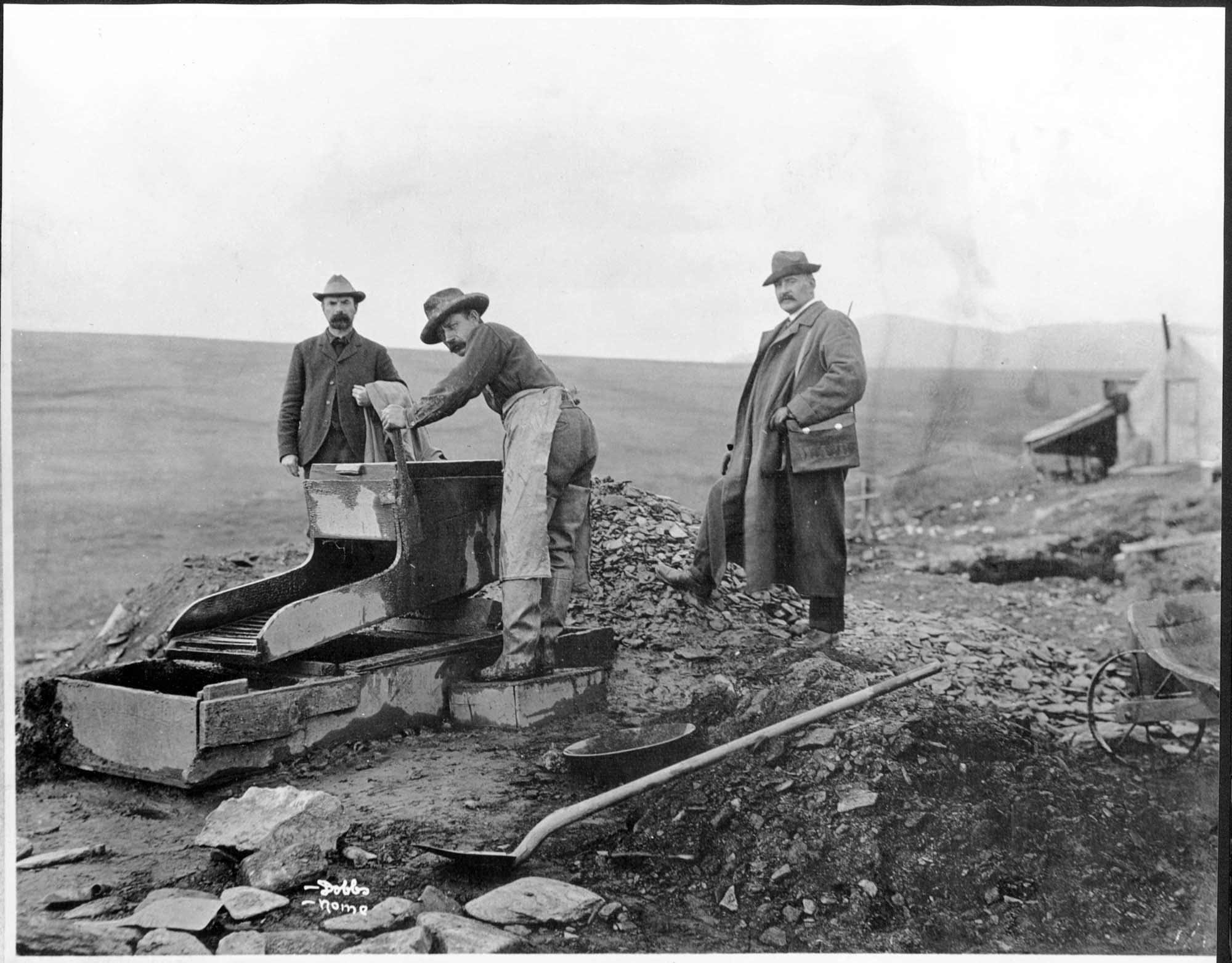 Image of Three men and a rocker in the Nome gold fields, circa 1905
