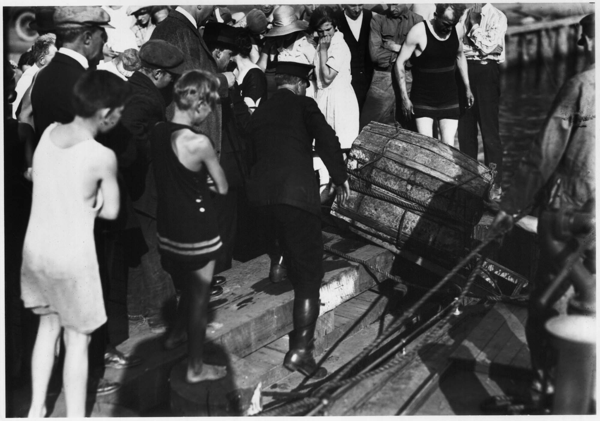 Image of Policeman pulling trunk with murder victim's body out of Lake Union, Seattle, August 8, 1921