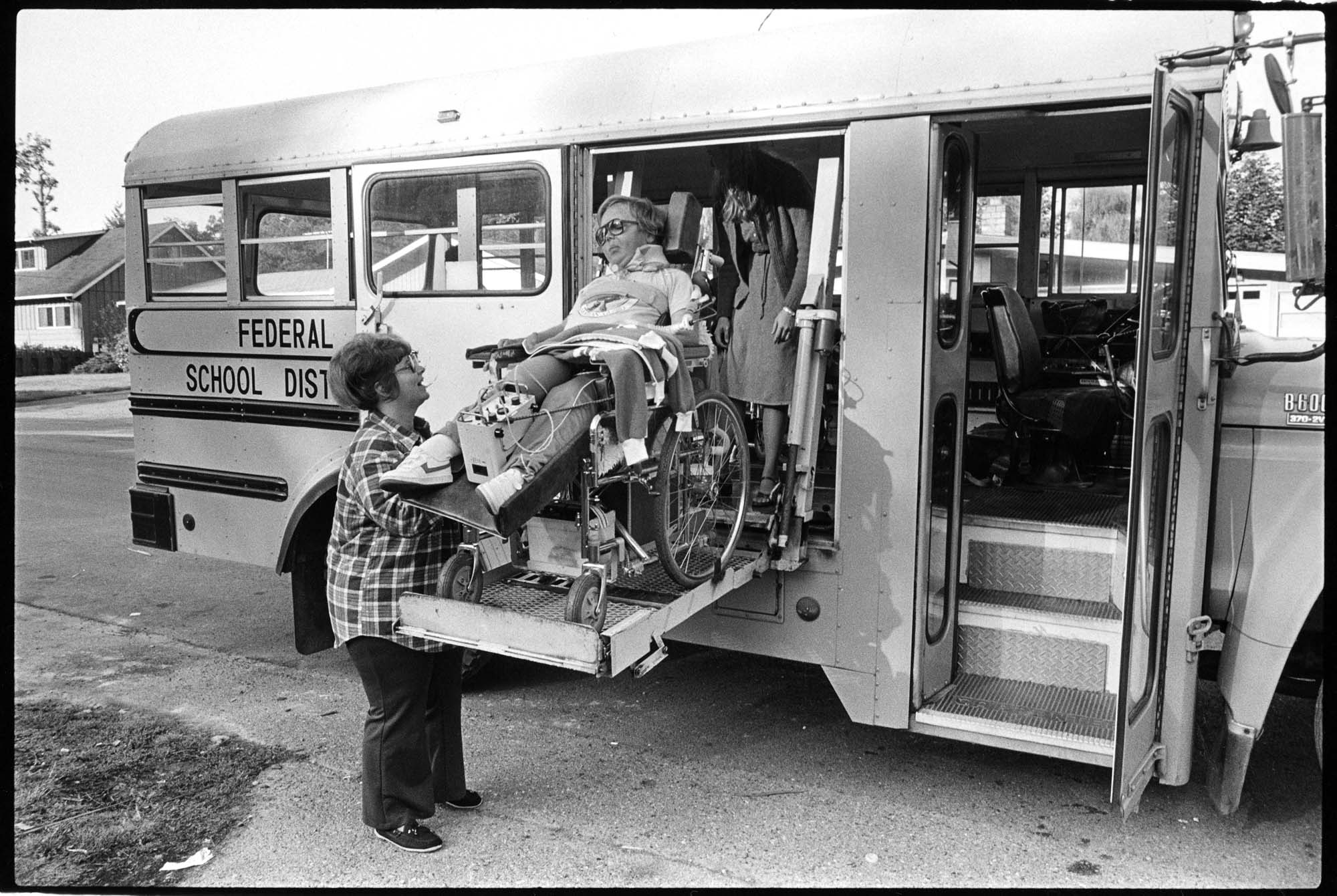 Image of Student in wheelchair using lift on school bus, Federal Way, September 23, 1983