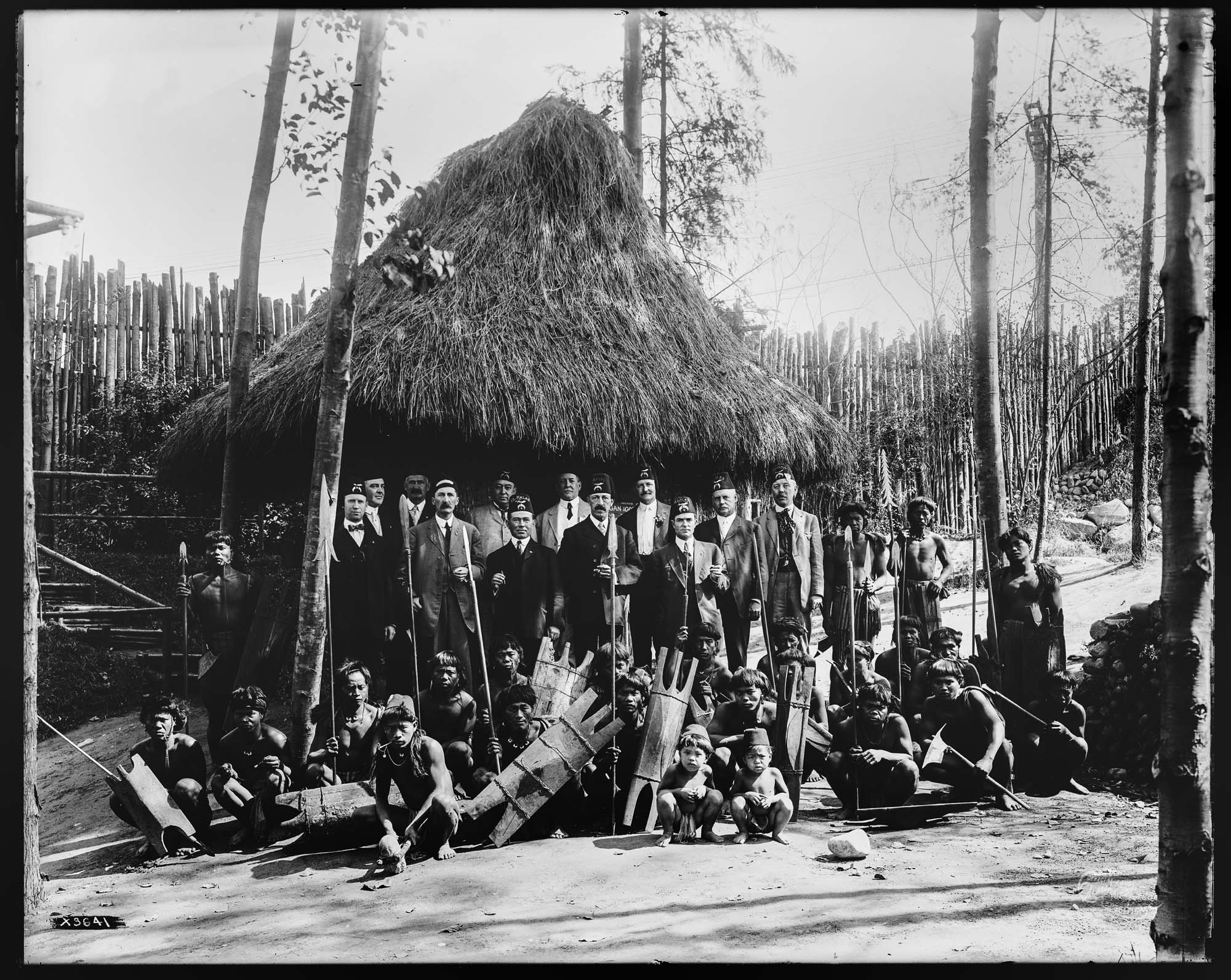 Image of Igorot men and children with Masonic Lodge Members in front of Igorot hut, Alaska-Yukon-Pacific Exposition, Seattle, 1909