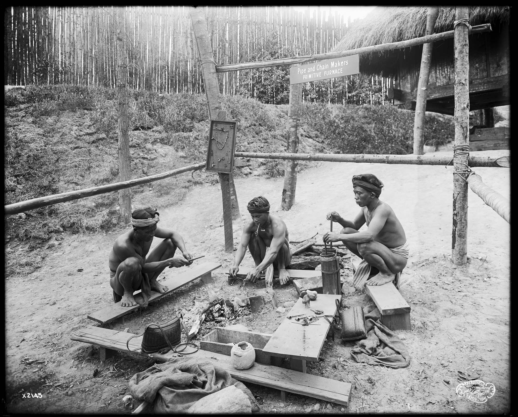 Image of Igorot pipe makers in exhibit at Alaska-Yukon-Pacific Exposition, Seattle, 1909