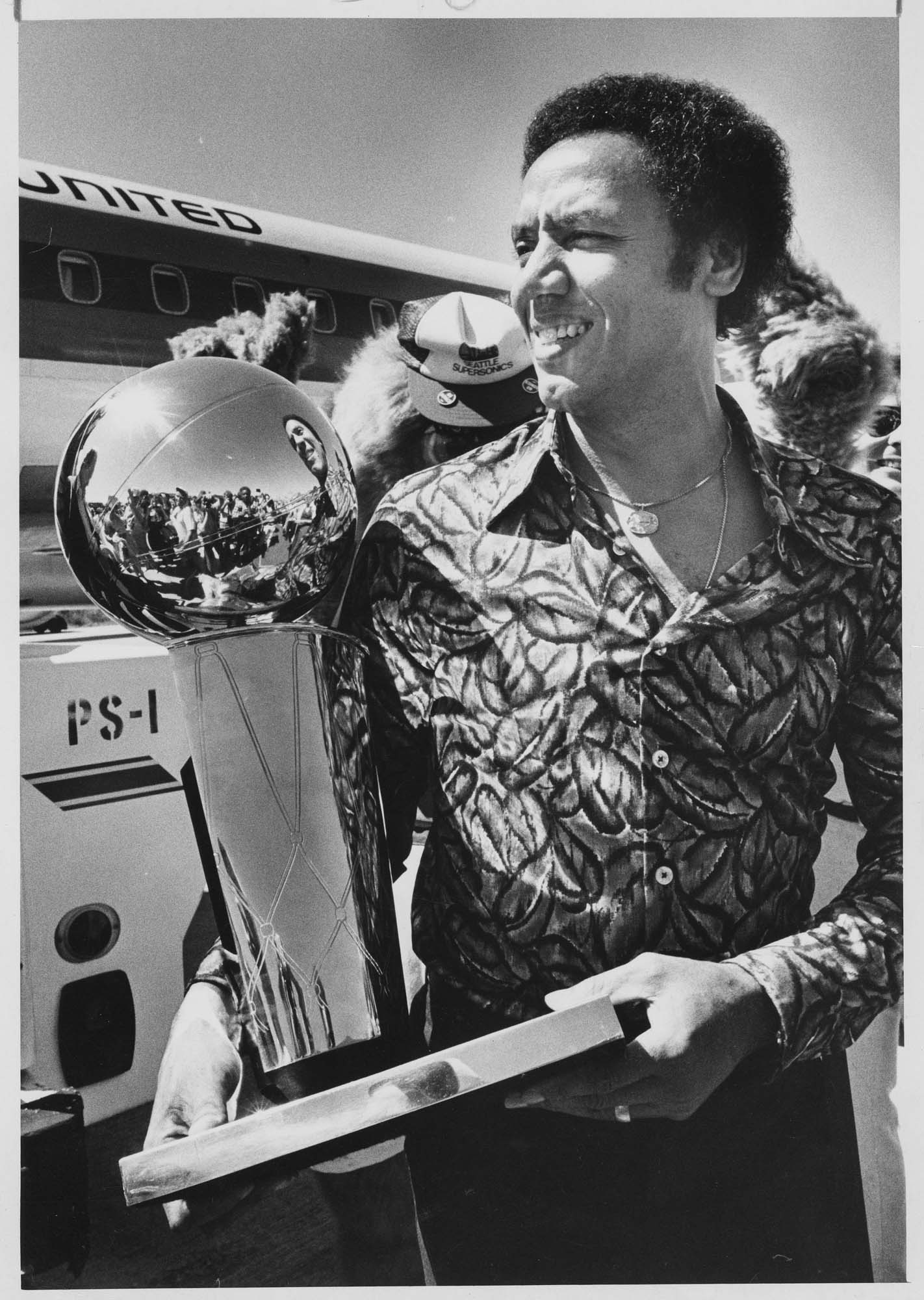 Image of Lenny Wilkens with championship trophy after arriving at Sea-Tac airport, June 2, 1979