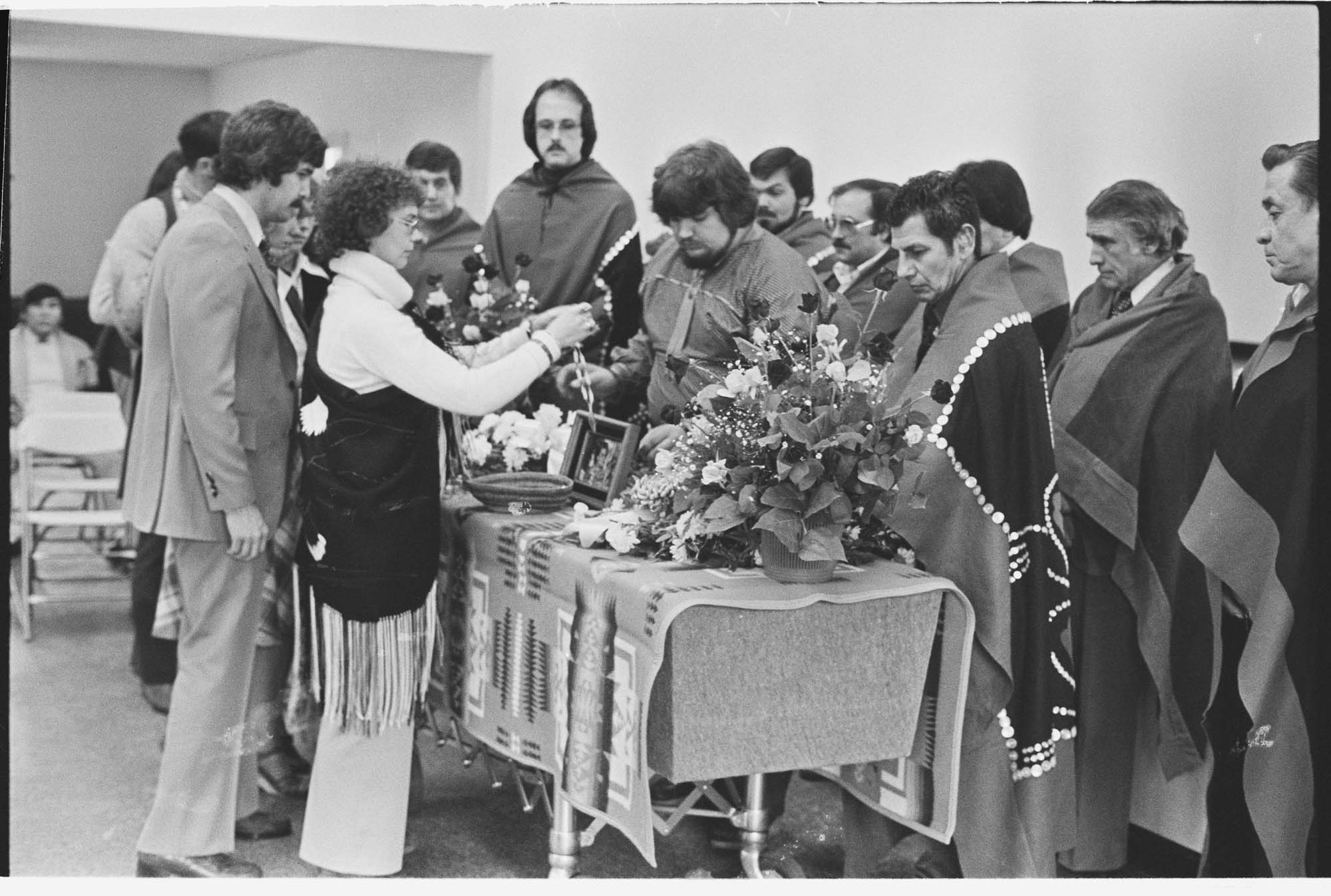 Image of Mourners placing gifts on bier at funeral for Kathleen Bishop, Port Townsend, February 16, 1978
