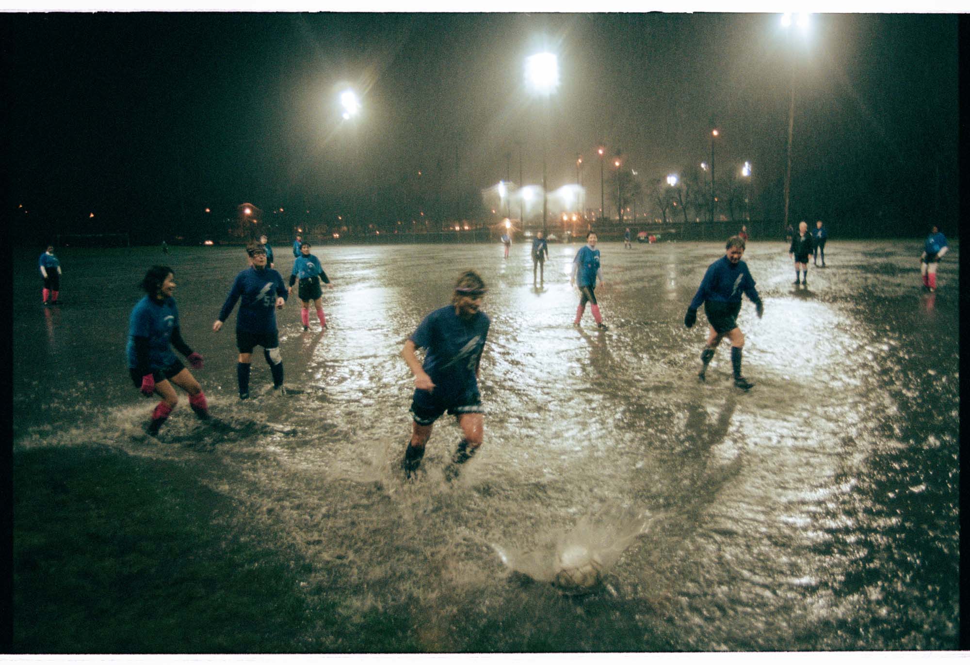 Image of Players in an over-50 women's soccer game in the heavy rain at Woodland Park, Seattle, March 18, 1997