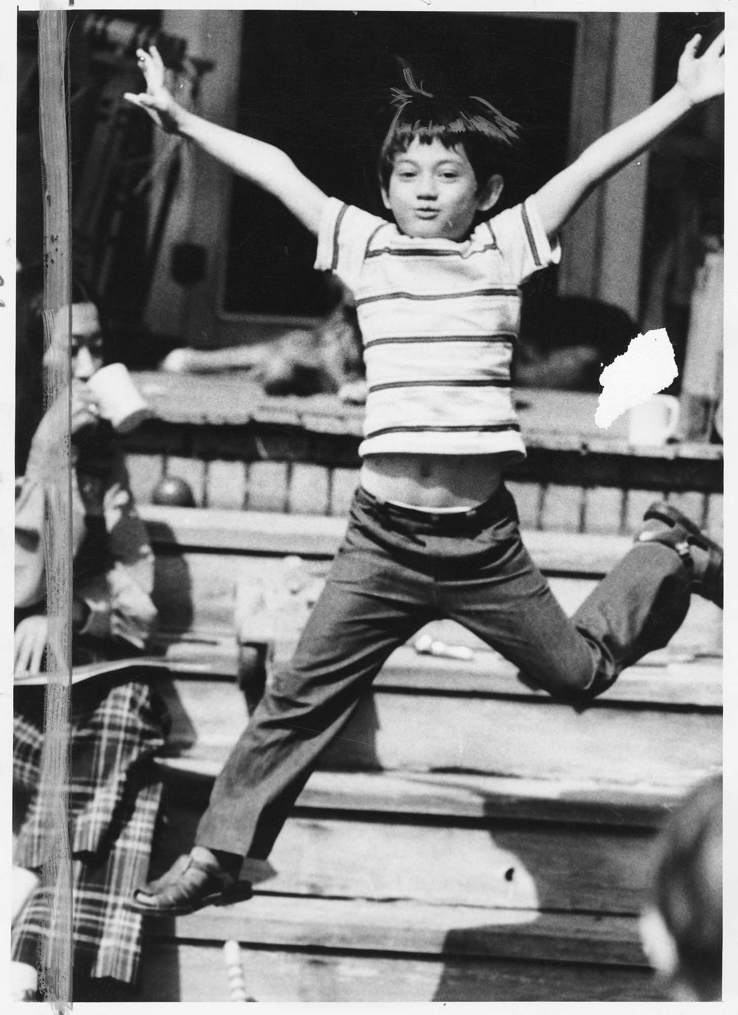 Image of Lê Quốc Thân leaping off the porch of his foster home, Renton, April 8, 1975