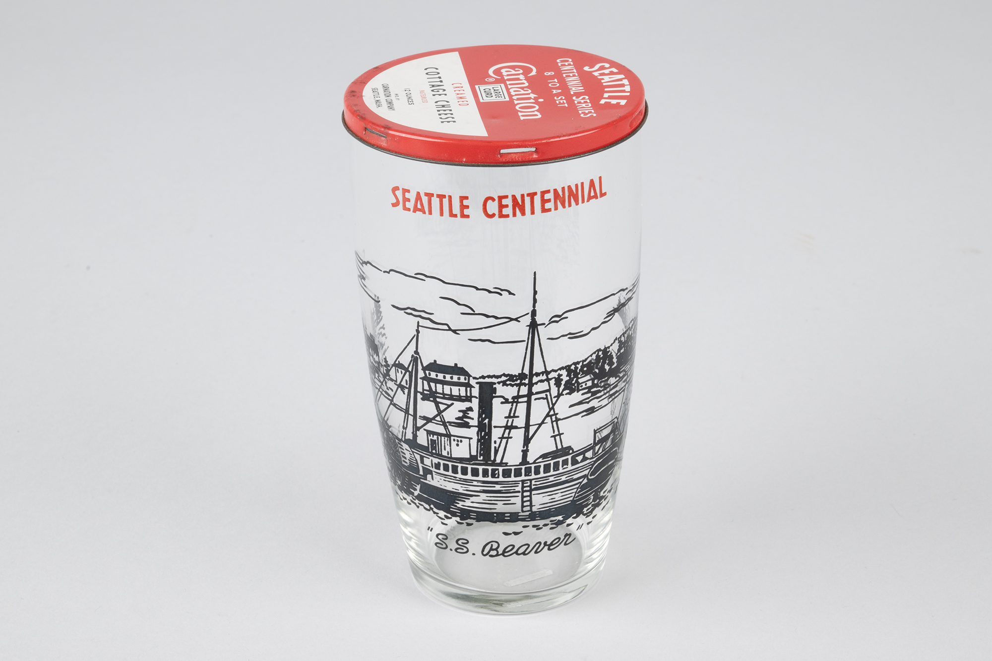 Image of Set of eight Seattle Centennial glasses with Carnation Cottage Cheese tin lids, 1952