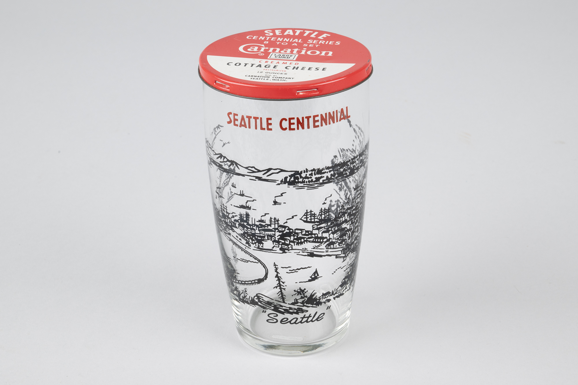 Image of Set of eight Seattle Centennial glasses with Carnation Cottage Cheese tin lids, 1952