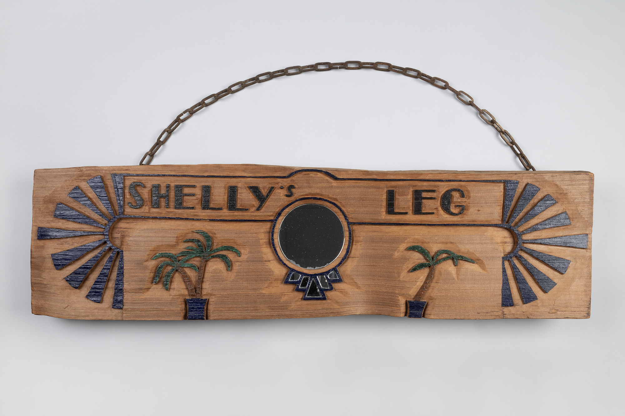 Image of Shelly's Leg wooden sign with palm trees and mirror, ca. 1973