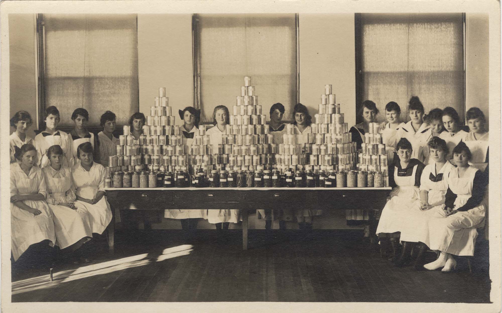 Image of Young women with stacks of cans, circa 1915