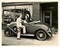 Image of Helene Madison and two men near car in front of Eldridge Buick, Pike Street, Seattle, September 1932