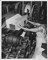 Image of Woman at Bemis Bag Co. plant loading finished bags onto machine, circa 1950