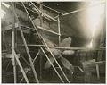 Image of Robert Moran posing near a propeller at Moran Brothers shipyard, Seattle, circa 1899
