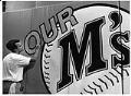 Image of Mark Popich working on Mariner's sign at stadium, July 16, 1992
