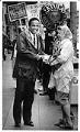 Image of Norm Rice shaking woman's hand on California Ave., West Seattle, November 8, 1989