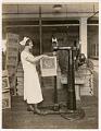 Image of Employee operating carton stapling machine at Crescent Manufacturing Company, Seattle, circa 1923