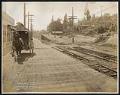Image of View south on Alki Avenue during regrade, showing rail tracks and homes, West Seattle, August 19, 1913