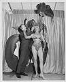 Image of John Eaton adjusting headpiece on model Donna Rydberg, 1961