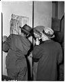 Image of Japanese American men looking at map of exclusion districts, Seattle, April 11, 1942