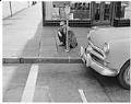 Image of Reporter Jack Jarvis measuring distance from parking meter to crosswalk, Seattle, October 1961