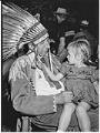 Image of Chief Yellow Lark with little girl on lap at Pow Wow, Seattle, August 20, 1950