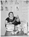 Image of AIWSL President Pearl Warren displaying Native American art, Seattle, January 1962