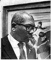 Image of Jacob Lawrence with his painting, Seattle, December 15, 1974