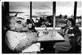 Image of Wheedle sitting with diners at the Space Needle, Seattle, July 19, 1982