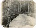 Image of Emil Schanno standing on bridge near Alki Point, Seattle, 1890