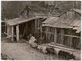 Image of Native American couple posing outside of wooden shack, Seattle, circa 1900