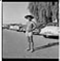 Image of Jason Gayle standing in parking lot in bathing suit and hat, Seattle, circa 1953