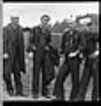 Image of Four Asian sailors posing in uniform, Seattle, circa 1953