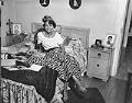 Image of Woman wearing party hat sitting on bed, Seattle, circa 1950