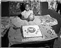 Image of Birthday girl posing with cake, Seattle, circa 1953