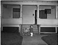 Image of Girl with doll carriage in front of house, Seattle, circa 1953