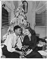 Image of Charlie Taylor and wife sitting in front of Christmas tree, Seattle, circa 1953