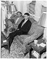 Image of Charlie Taylor, Sr. and his son sitting on couch, Seattle, circa 1953