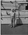 Image of Man standing on a dock with lumber, Seattle, circa 1953