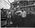 Image of Men shaking hands on a dock in front of a ship, Seattle, circa 1953
