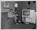 Image of Buddy Brashear sitting on living room couch, circa 1950
