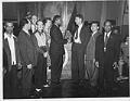 Image of Two men in group shaking hands at union office, circa 1944