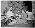 Image of Nancy Ramey and Suzie Ordogh exchanging Christmas gifts, December 1956