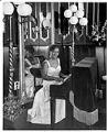 Image of Ruby Bishop posing at piano at Ivar's Restaurant, Seattle, February 2, 1958