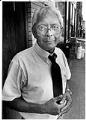 Image of Bob Santos standing on sidewalk in Chinatown - International District, Seattle, July 18, 1986