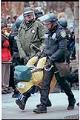 Image of Law enforcement officers carrying demonstrator at WTO protests, Seattle, December 1, 1999