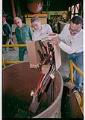 Image of Men dumping box of guns into foundry crucible, Seattle, June 16, 1993